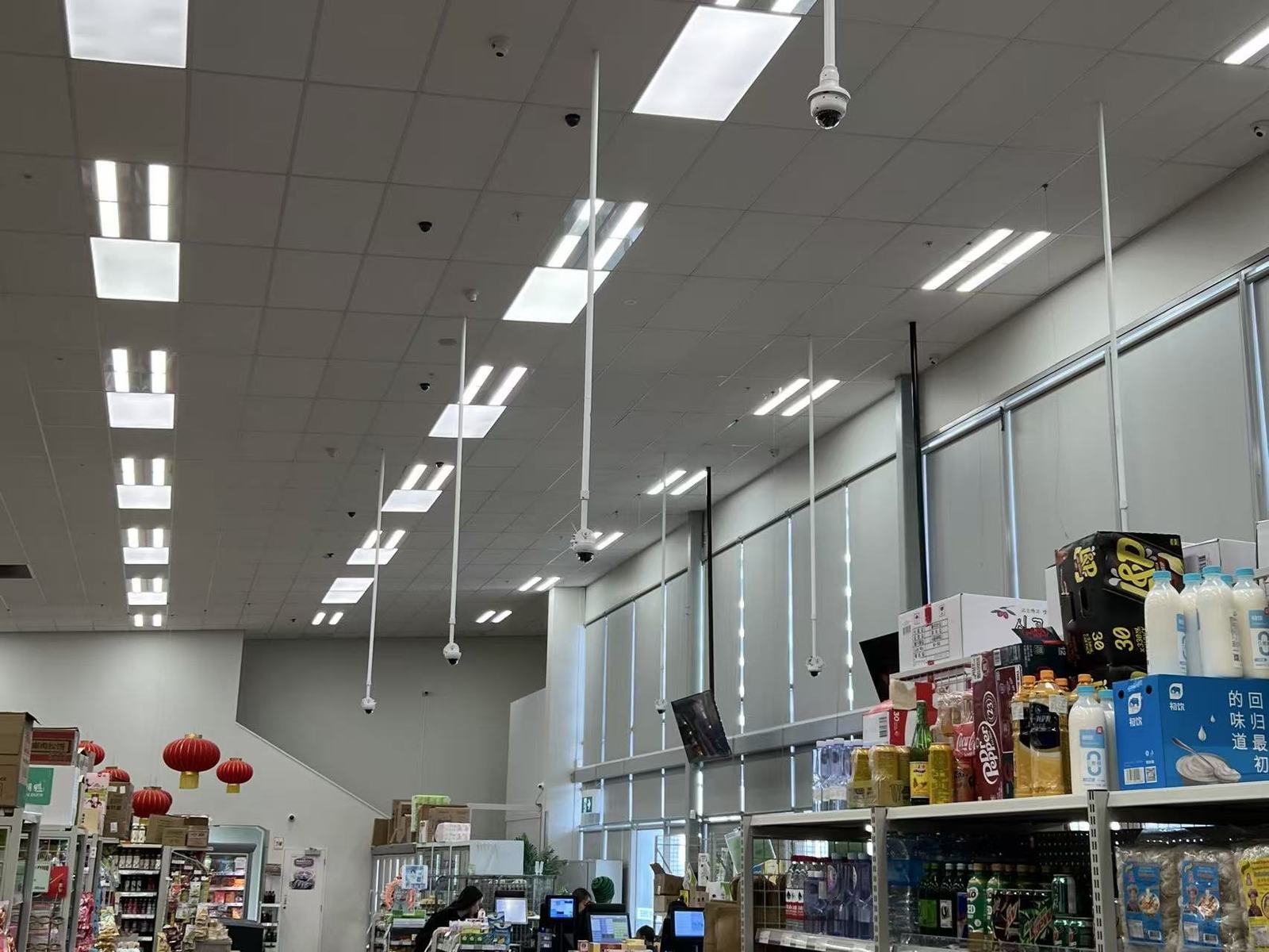 CCTV camera and screen near store entrance and shelving