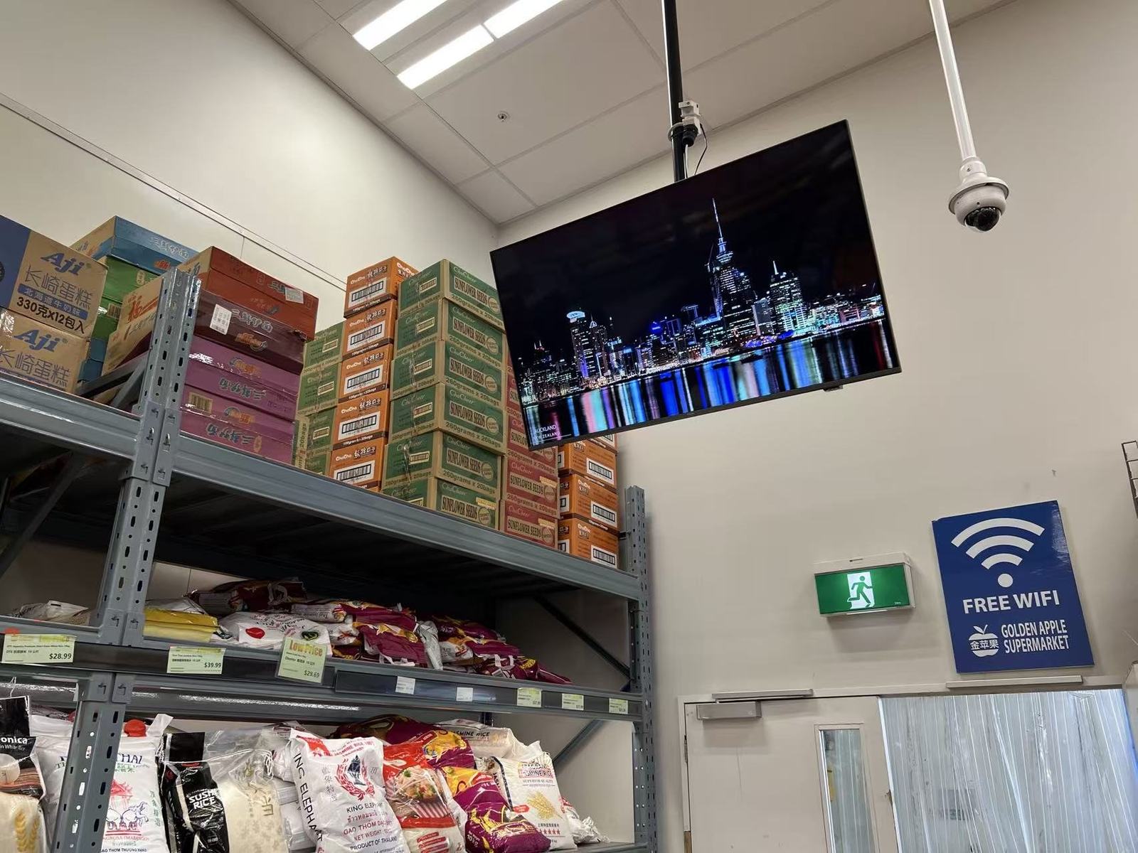 Golden Apple Henderson grocery shelves with ESL labels and overhead display