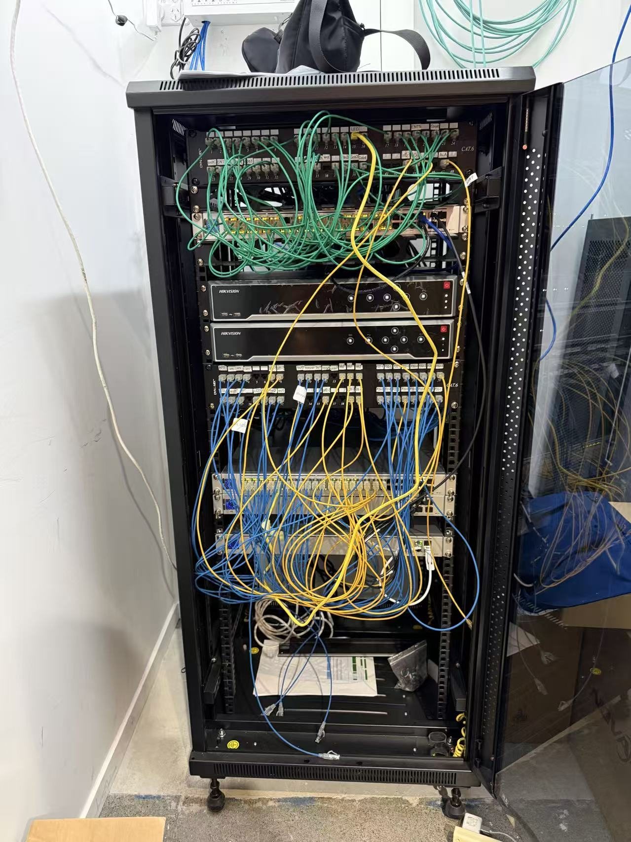 Network cabinet with patch panels, NVR, switches, and service cabling