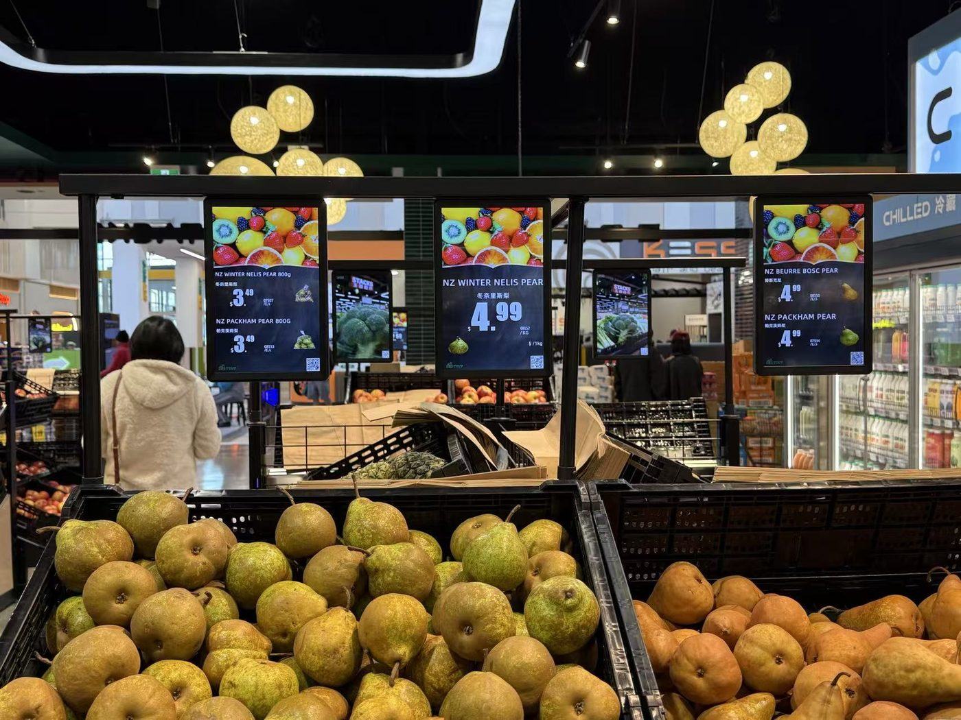 Digital ESL displays above a premium produce display